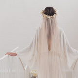 Bride wearing a long soft English tulle veil and floral crown for a dreamy ethereal bridal look